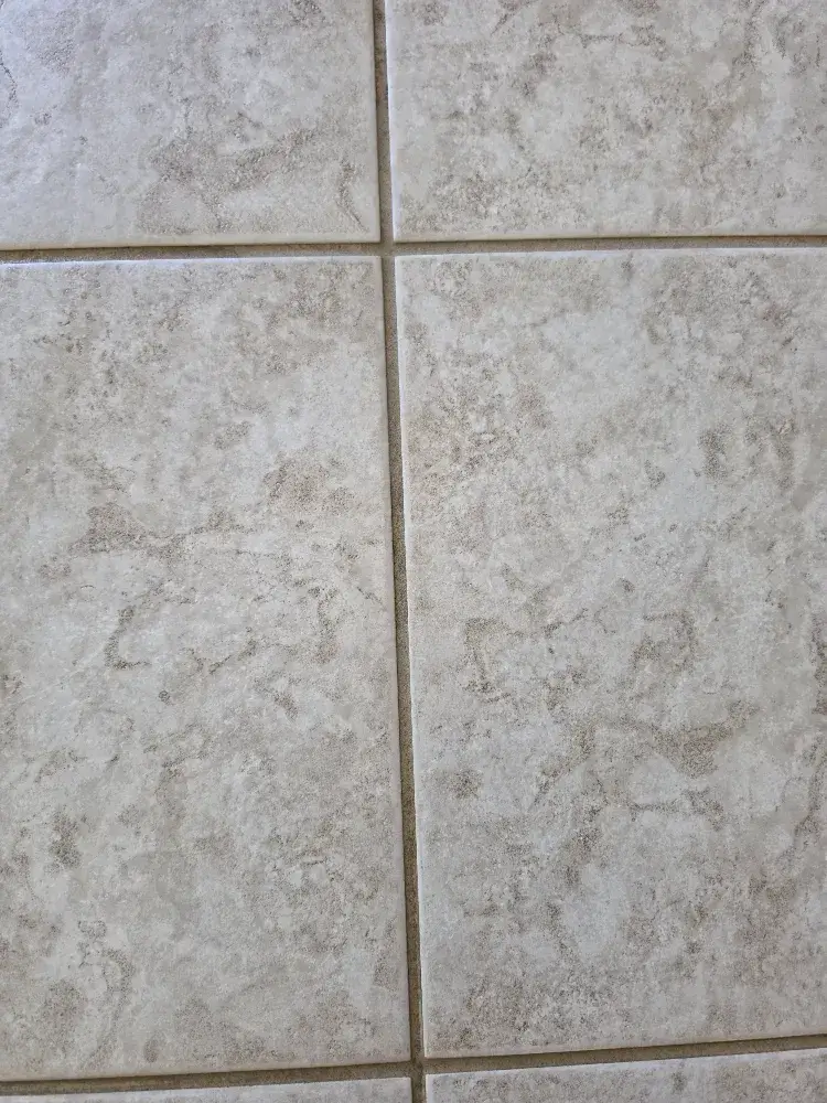 Extreme close-up of grey square ceramic tile in a Wildomar home, showing perfectly clean and uniform light-colored grout lines after professional cleaning by The Dirt Army