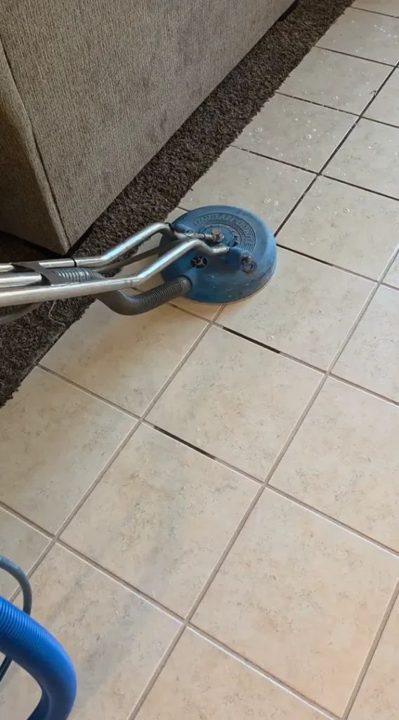 The Dirt Army cleaning tile safely alongside living room carpet and furniture borders